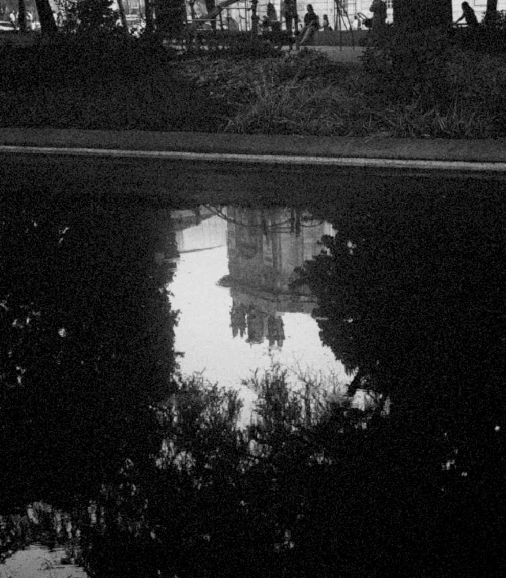black and white image of a reflection of a building in water